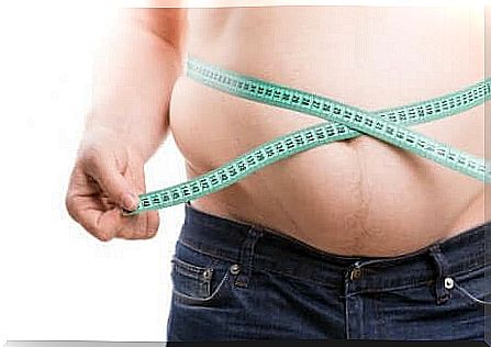 Overweight man measures the abdominal circumference.