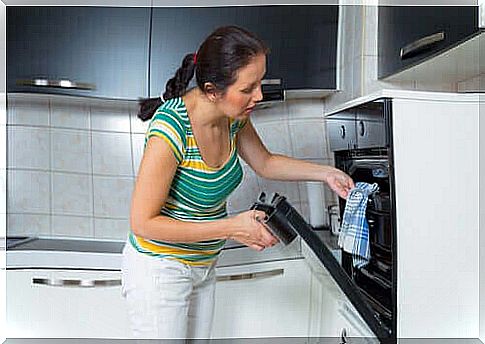 Woman takes a baking sheet out of the oven