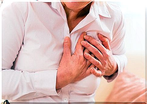 Woman with hand on chest for heart attack