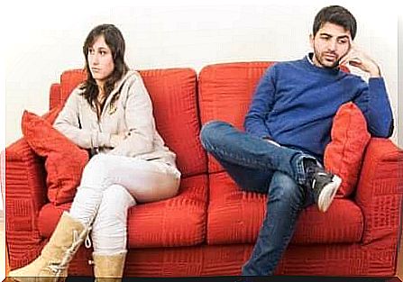 Couple sitting distant on the sofa.