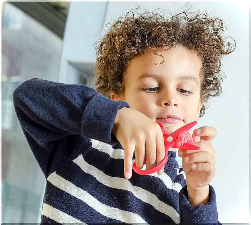 Child playing with scissors and wax 