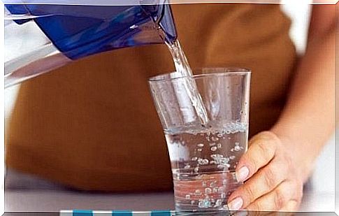 Woman pours water into a glass