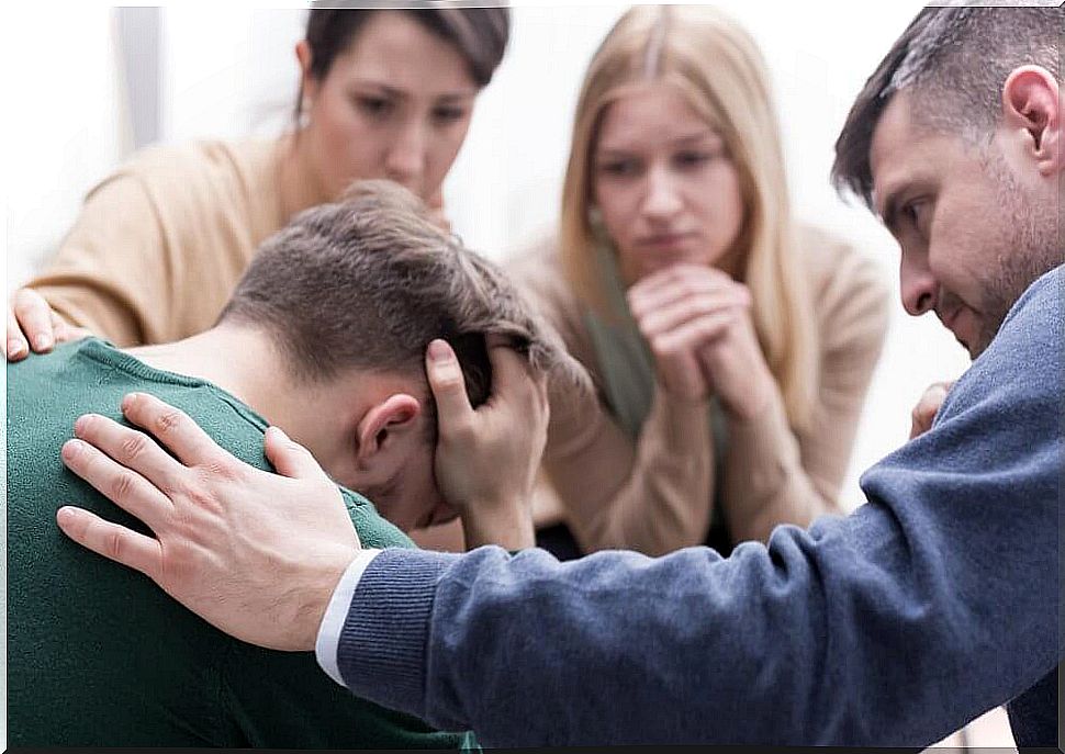 Man consoled by friends