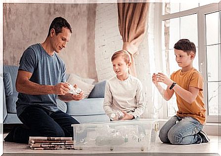 Father and children separate the plastic from the cardboard.