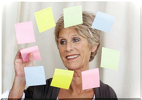 Mature woman sticks post it on the glass