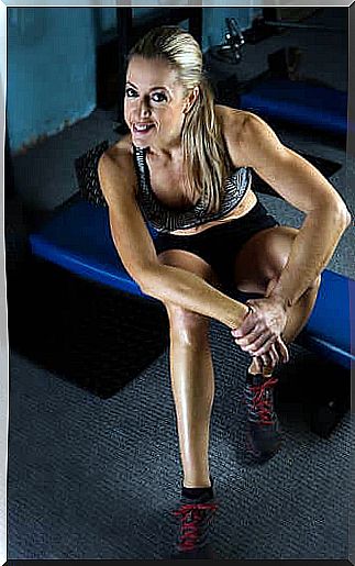 Sportswoman sitting on the bench in the gym